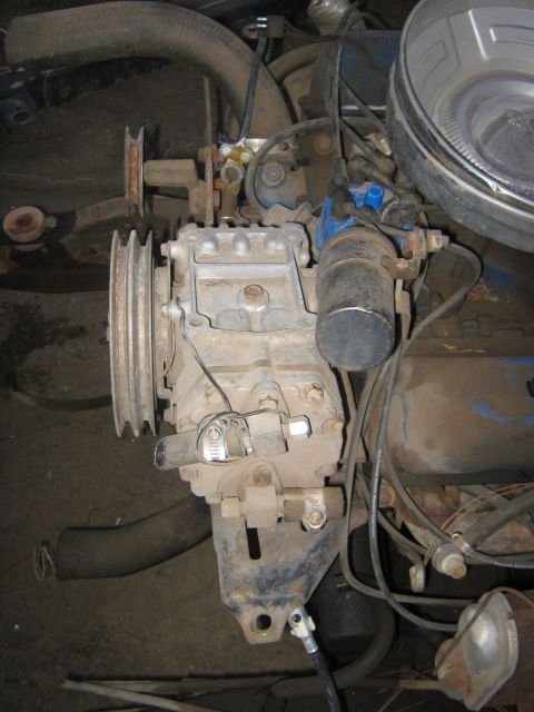 1972 Ford F-250 - Close-up view of an engine compartment, focusing on the air conditioning compressor and associated pulleys.