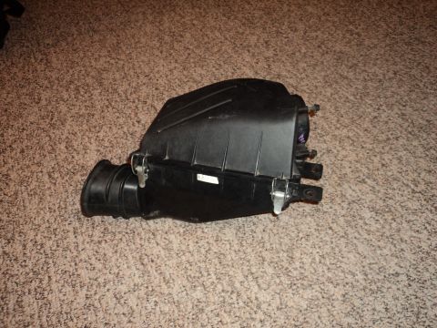 2004 Mercury Grand Marquis - This is an air intake box, likely from a vehicle, shown on a carpeted surface. The registry claims it is from a 2004 Mercury Grand Marquis,…