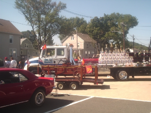 Fire truck with 'Big Dog Towing' on side, pulling a trailer with trophies and a small wagon
