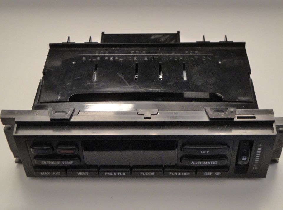 Car climate control unit with buttons for outside temp, max a/c, vent, pnl & flr, floor, flr & def, off, and automatic