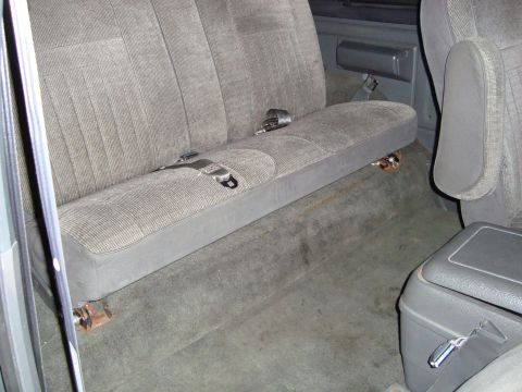 1991 Ford Bronco - Rear bench seat interior view, showing seatbelts and carpeted floor.