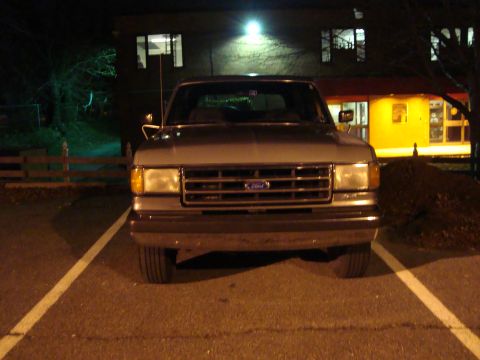 1991 Ford Bronco - This 1991 Ford Bronco is captured from the front at night, parked in a lot.