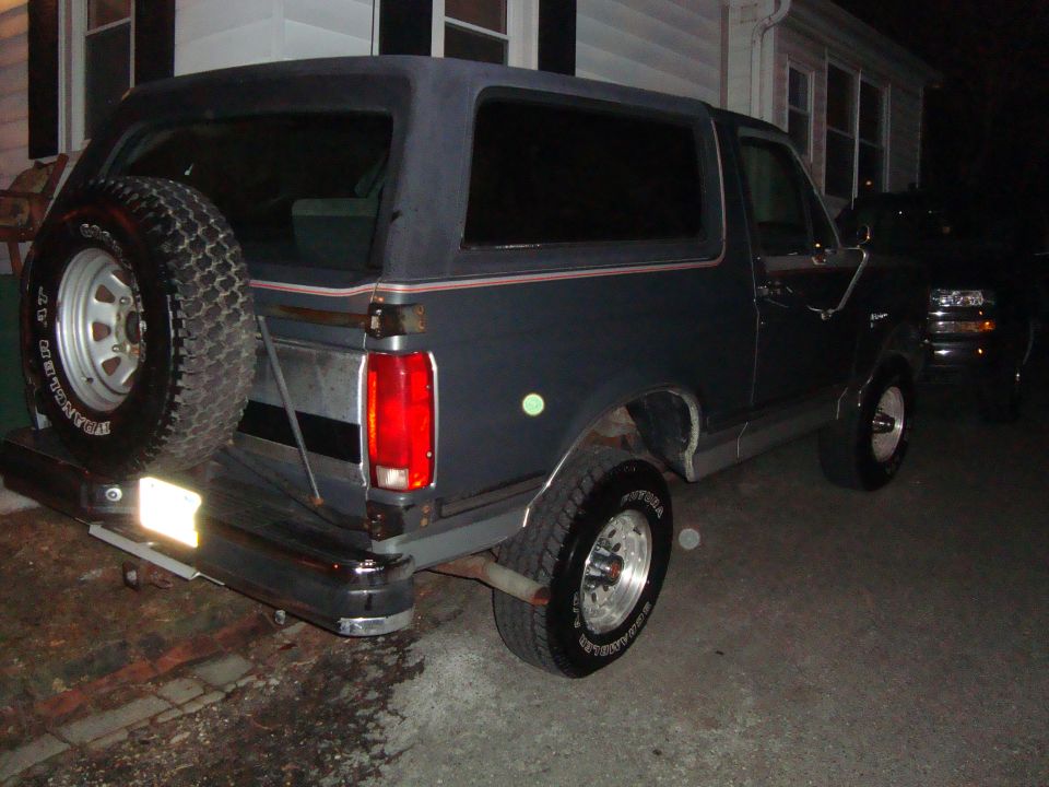 1991 Ford Bronco rear view, dark blue with spare tire mounted externally