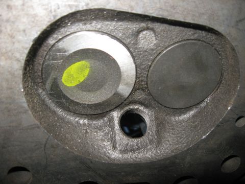 1981 Ford Bronco - Close-up view of an engine cylinder head, showing two valve openings and a distinctive yellow mark on one valve seat.