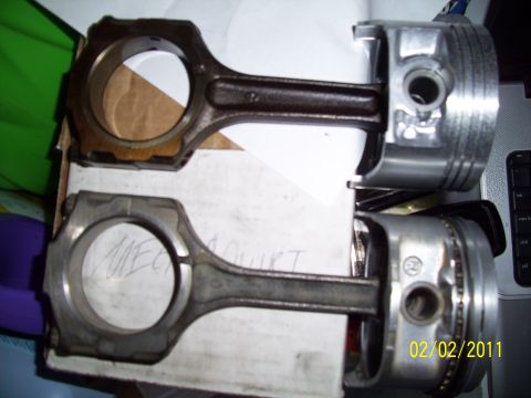1995 Ford Probe - A close-up shows two engine pistons with connecting rods, one appearing more worn than the other.