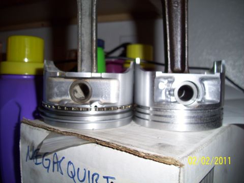 1995 Ford Probe - Close-up view of two engine pistons and their connecting rods, with visible piston rings on one.