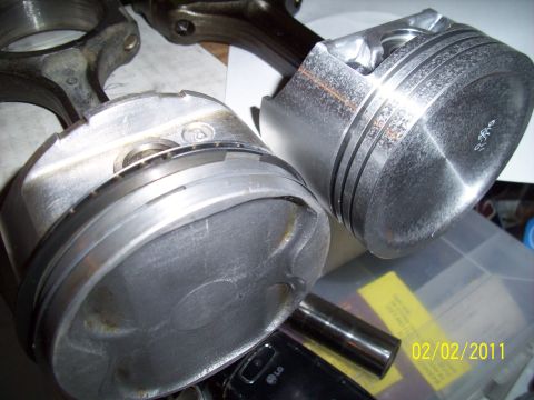 1995 Ford Probe - Engine pistons and connecting rods are shown, with some faint markings on one piston.