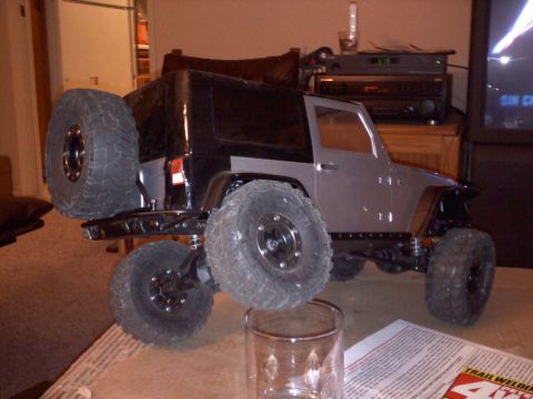 1993 Toyota 4Runner - A toy remote-controlled car with off-road tires is displayed on a table, with electronics and a television in the background.