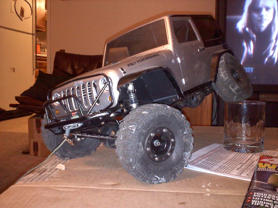 Silver RC Jeep Wrangler with "Poly Performance" text on fender
