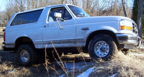 1996 Ford Bronco - This 1996 Ford Bronco is shown in a three-quarter front view, parked in a natural, outdoor setting.