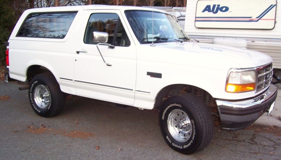 White 1996 Ford Bronco parked outside, with a trailer behind it