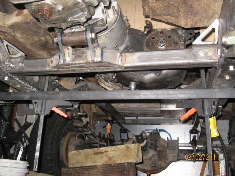 1961 International Scout 800 - The undercarriage of a vehicle is shown, focusing on the drivetrain components like the transmission and differential.