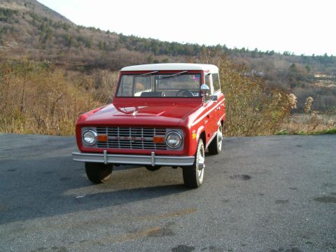 1971 Ford Bronco - A classic red 1971 Ford Bronco is shown from the front, parked outdoors on a paved surface.
