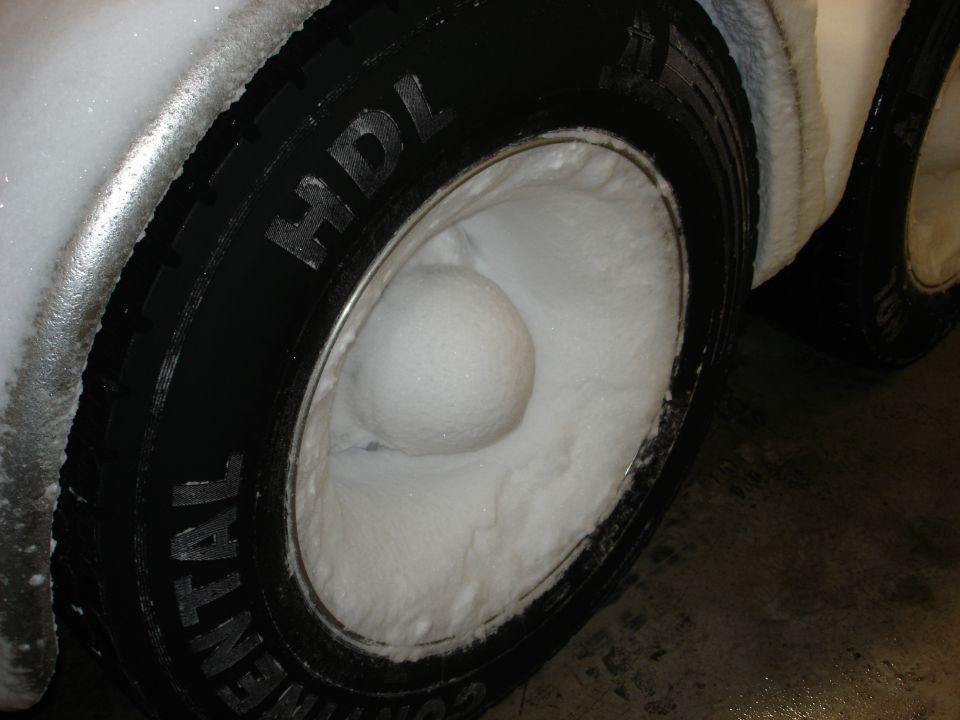 Close-up of a tire filled with snow, with 'CONTINENTAL HDI' visible on the sidewall