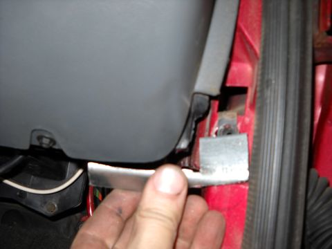 1993 Ford C-150 (Centurion Conversions) - Close-up of a vehicle's interior door latch mechanism, with a hand holding a metal component.