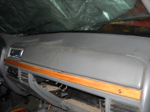 1993 Ford C-150 (Centurion Conversions) - Interior view of a gray dashboard wood trim and an aftermarket radio, with the glove compartment open.