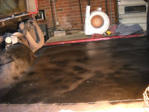 1993 Ford C-150 (Centurion Conversions) - The interior floor of a vehicle appears dark and possibly wet, with some hoses and equipment in the background.