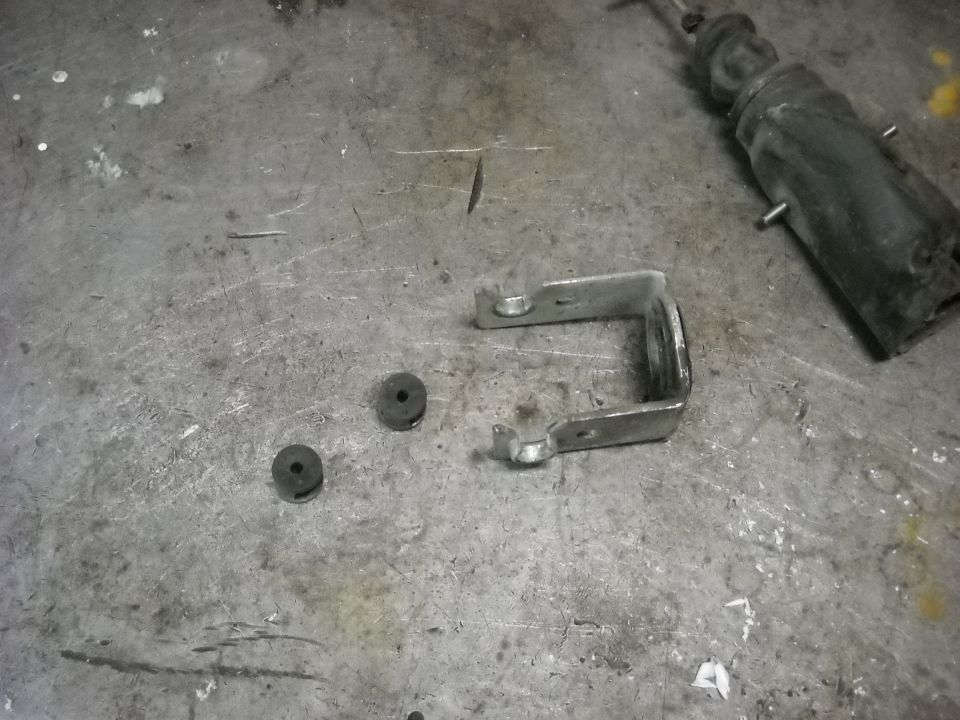 Door lock actuator and bracket with two rubber grommets on a metal surface