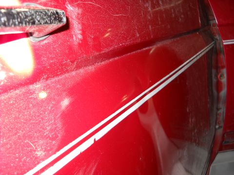 1993 Ford C-150 (Centurion Conversions) - Detail of a red vehicle door with a chrome handle and double white pinstripes.