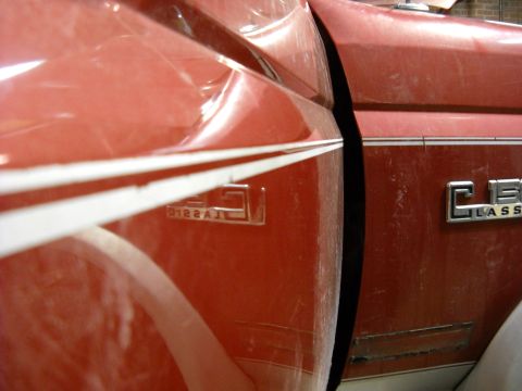 1993 Ford C-150 (Centurion Conversions) - A dent is visible on the side panel of a red pickup truck, near the 'CLASSIC' emblem.