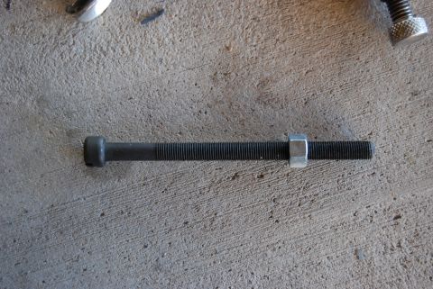 1982 Ford Bronco - A bolt and nut are shown on a concrete floor.