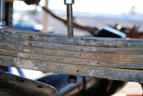 1982 Ford Bronco - The photo shows a close-up view of a vehicle's rusty leaf spring assembly, with bolts visible.