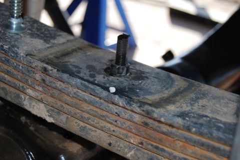 1982 Ford Bronco - Close-up view of a vehicle's leaf spring assembly, highlighting mechanical components and signs of age.