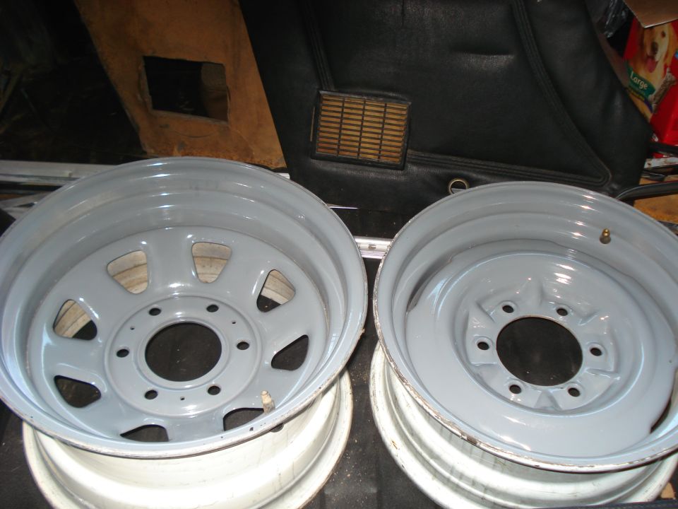 Two gray painted steel wheels with five lug holes
