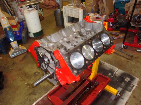 1989 Ford Bronco - An engine block sits on a stand in a cluttered garage, ready for assembly or after a rebuild.