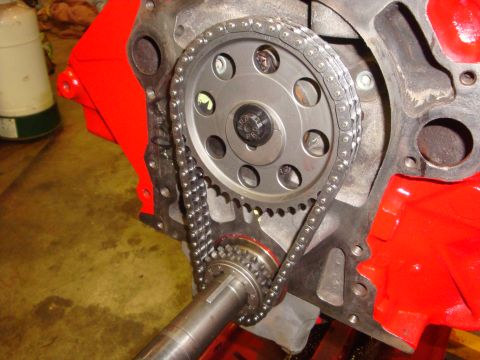 1989 Ford Bronco - Engine timing chain and gears assembly on a red-painted engine block.