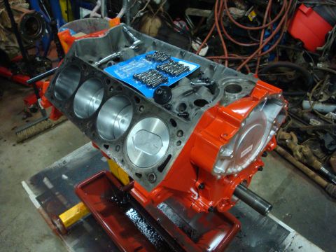 1989 Ford Bronco - Engine block on a stand, ready for assembly, with a set of bolts on top.