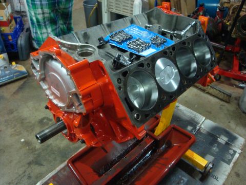 1989 Ford Bronco - Engine block assembly on a stand, ready for rebuild with new bolts and pistons visible.
