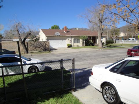 1993 Ford Taurus - A white sedan is parked on the street in front of a house, with another car visible in the background.