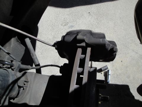 1993 Ford Taurus - Close-up view of a vehicle's brake caliper and associated hardware, suggesting a repair or maintenance context.