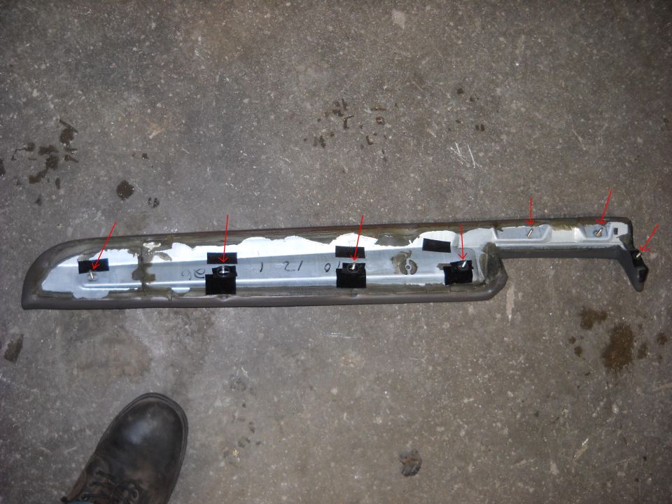 Back of removed body-side trim molding with red arrows marking retaining clips