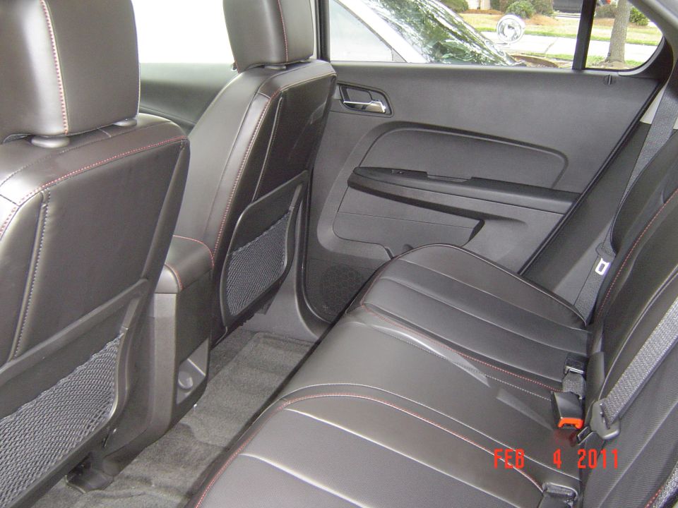 Black leather rear seats with red stitching inside an SUV, dated Feb 4 2011