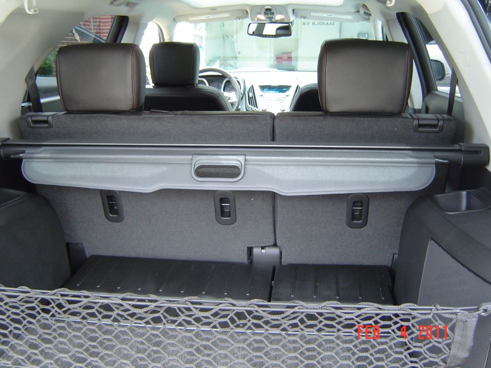 Rear cargo area of an SUV with gray cargo cover and black cargo net