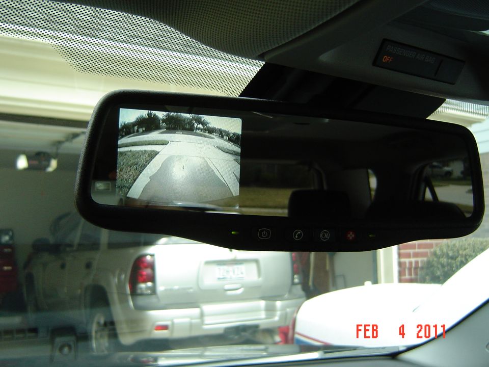 Rear-view mirror with built-in backup camera display and OnStar buttons in a car interior
