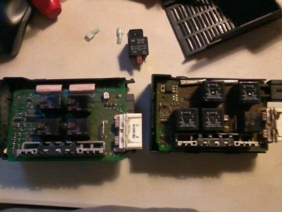 Two electronic control modules with relays and connectors on a surface
