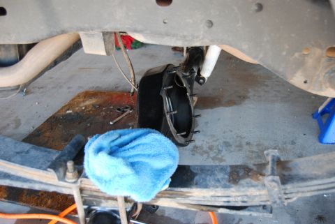 1982 Ford Bronco - The undercarriage of a vehicle is shown, with components like leaf springs and a shock absorber visible.