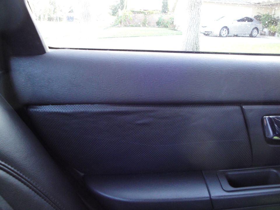 Black rear door panel with perforated insert and chrome interior handle