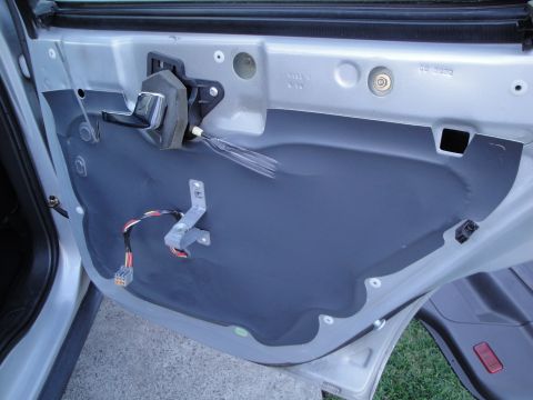 2003 Ford Taurus - Car door's internal structure and wiring exposed after panel removal.