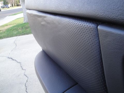 2003 Ford Taurus - Interior door panel with perforated leather texture, possibly from a Ford Taurus.