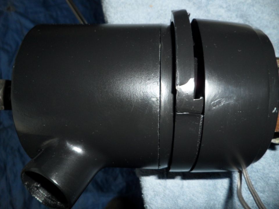 Black steering column shroud with a metal bracket attached