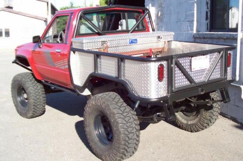 1989 Ford Bronco - This modified pickup truck has a custom flatbed and large tires, suggesting off-road use.