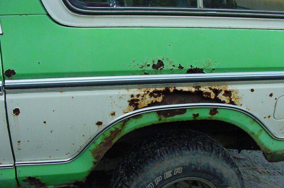 1979 Ford Bronco side panel with significant rust damage above the rear wheel well