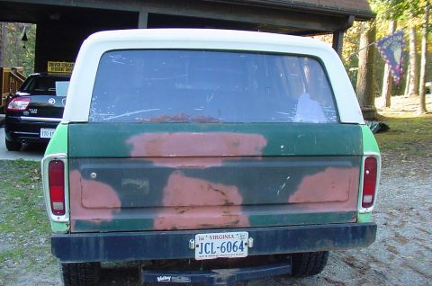 1979 Ford Bronco - The rear of a Ford Bronco shows camouflage paint and a Virginia license plate.