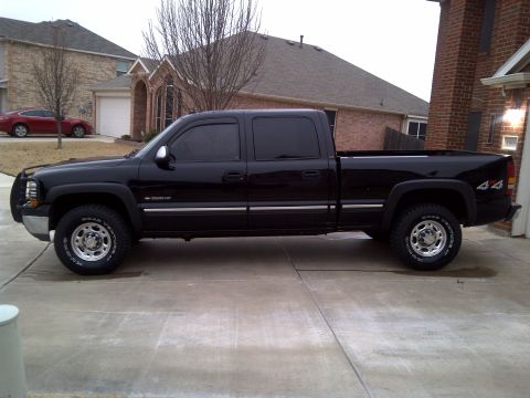 2002 Chevrolet Silverado 1500 - This black 2002 Chevrolet Silverado 1500 pickup truck is shown from the side, its 4x4 badging and crew cab configuration.