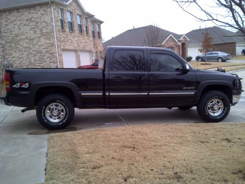 2002 Chevrolet Silverado 1500 - Side view of a black 2002 Chevrolet Silverado 1500 pickup truck parked in a driveway.