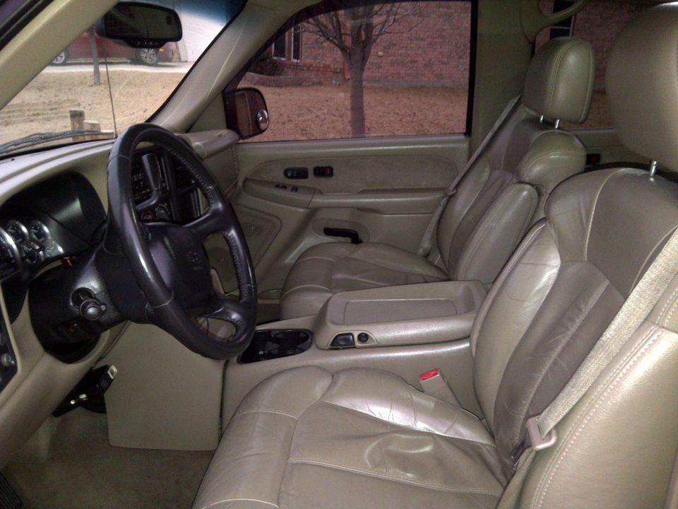 Tan leather interior of a 2002 Chevrolet Silverado 1500, showing the driver's side dashboard, steering wheel, and front passenger seats